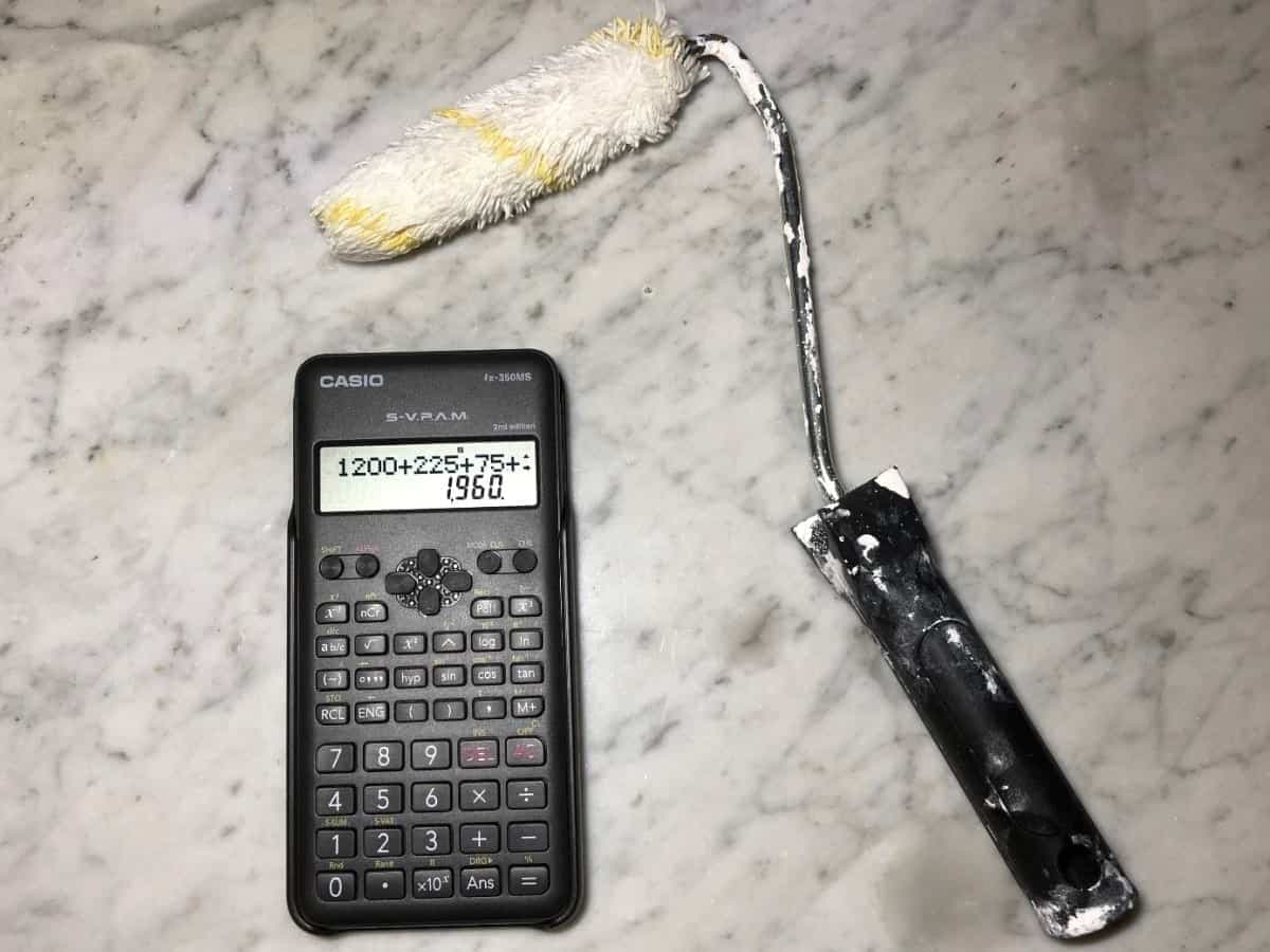 Ein Taschenrechner mit einer Farbrolle auf einer Marmorplatte