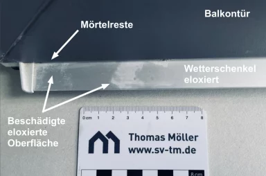 Ein eloxierter Aluminium-Wetterschenkel an einer Terrassentür. Der Schenkel hat Flecken und es sind Mörtelreste zu erkennen.