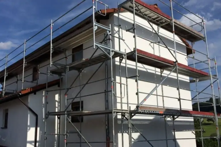Eine frisch gestrichene Fassade eines Einfamilienhauses mit Gerüst.