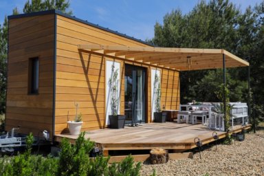 Tiny House aus Holz mit Terrasse im Sonnenschein